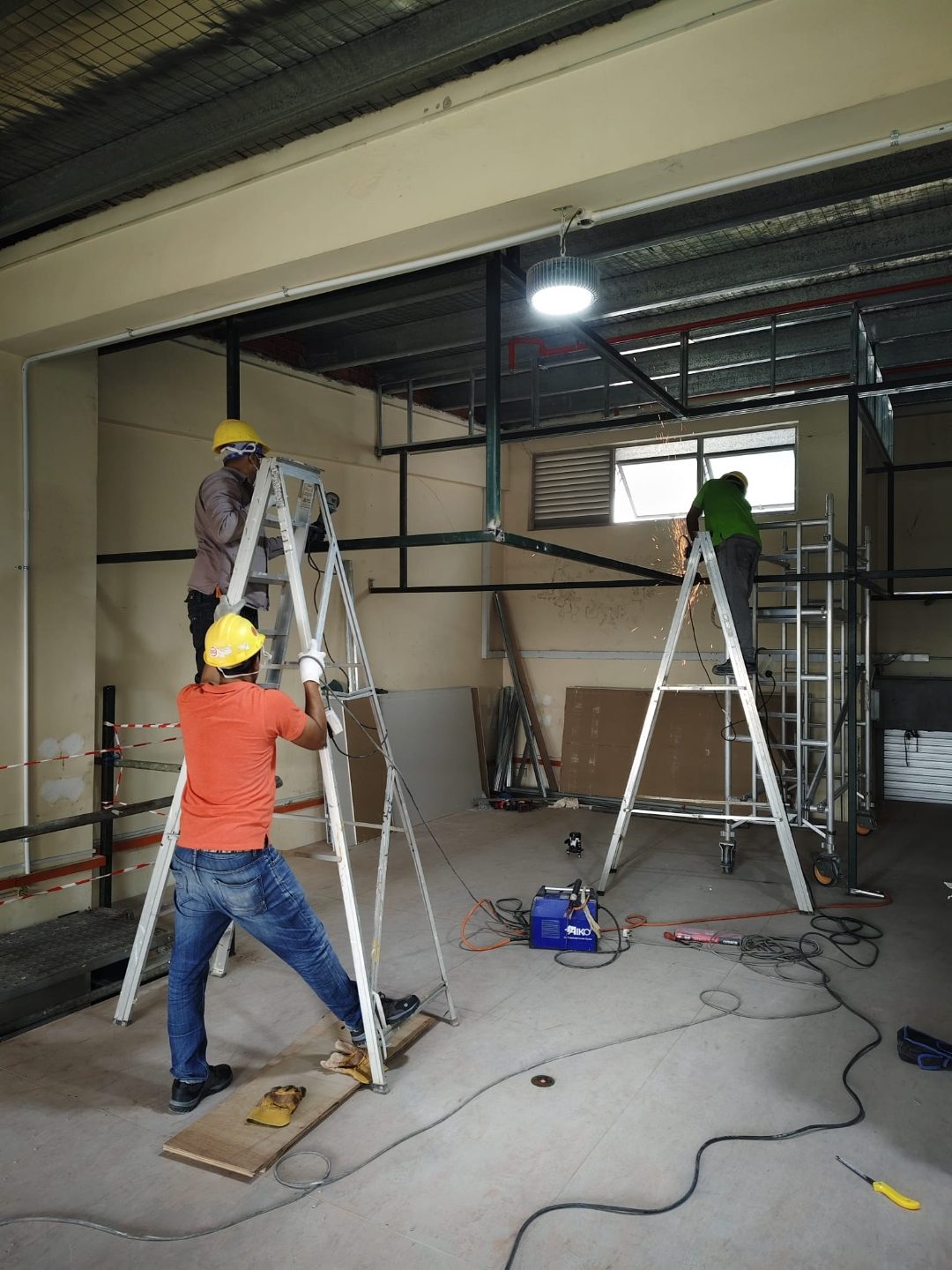 Worker on a step ladder fitting mezzanine steel framing at Frontier Industrial Building